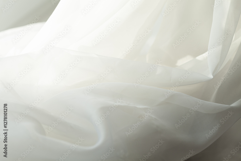 Obraz premium Abstract waves of sheer white fabric, softly illuminated, evoke purity and simplicity. A delicate dance of light and texture.