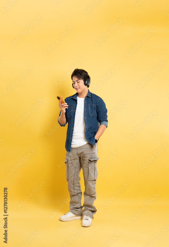 Fototapeta premium Portrait of asian man posing on yellow background.