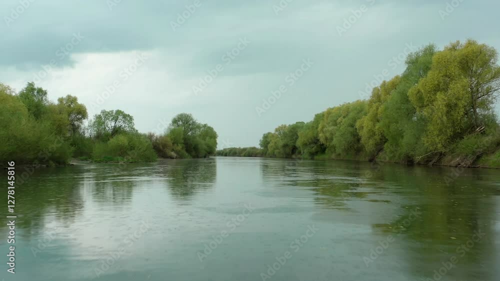 A serene drone flight over a tranquil river, capturing calm waters reflecting the sky and surrounding nature. Smooth movement reveals a peaceful, scenic landscape, perfect for relaxation and meditatio A serene drone flight over a tranquil river, capturing calm waters reflecting the sky and surrounding nature. Smooth movement reveals a peaceful, scenic landscape, perfect for relaxation and meditatio