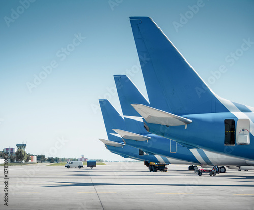 Obraz na płótnie Side shot of thee airplanes with blue tails at the airport