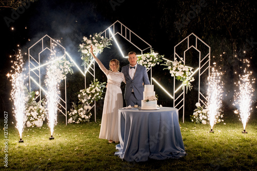 Obraz na płótnie newlyweds happily cut and taste the wedding cake w salonie