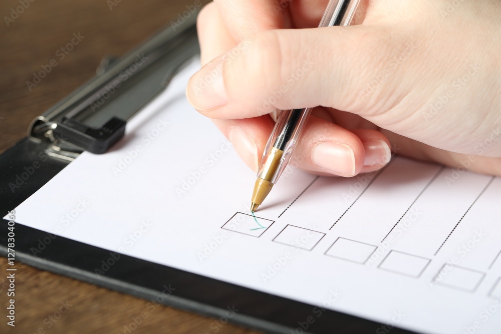 Woman checking box of paper form at table, closeup Woman checking box of paper form at table, closeup