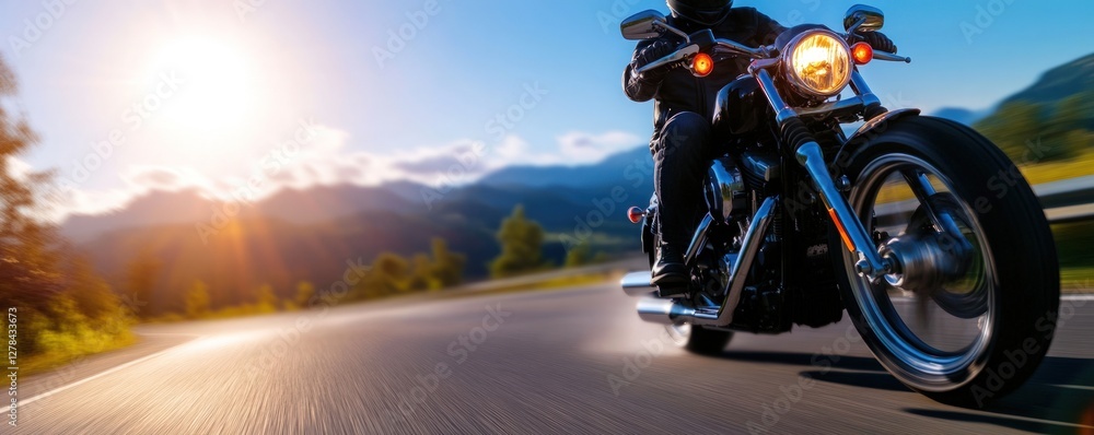 Obraz premium Motorcyclist rides scenic mountain road sunset