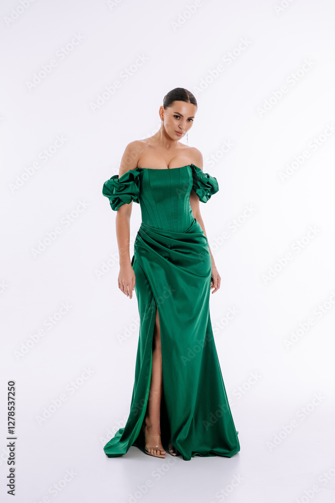 Beautiful brunette girl in a green and emerald evening dress on a white background isolated Beautiful brunette girl in a green and emerald evening dress on a white background isolated