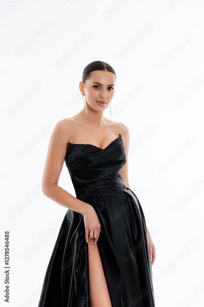 Beautiful tender brunette girl in a black dress with a train. Evening dress isolated on a white background Beautiful tender brunette girl in a black dress with a train. Evening dress isolated on a white background