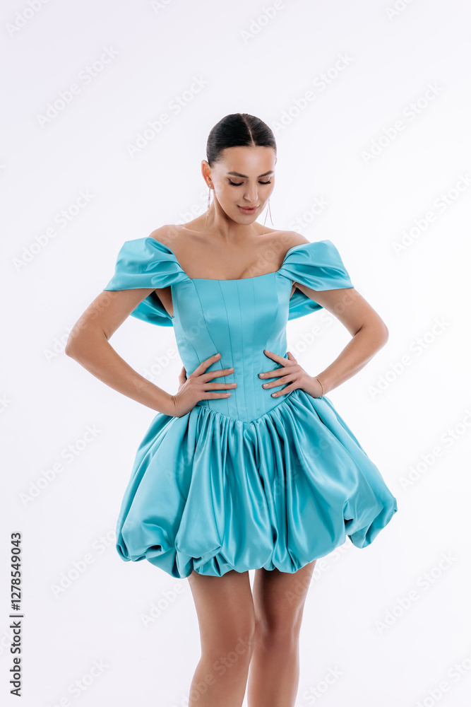 Sexy mulatto girl in a short evening luxury turquoise dress on a white background Sexy mulatto girl in a short evening luxury turquoise dress on a white background