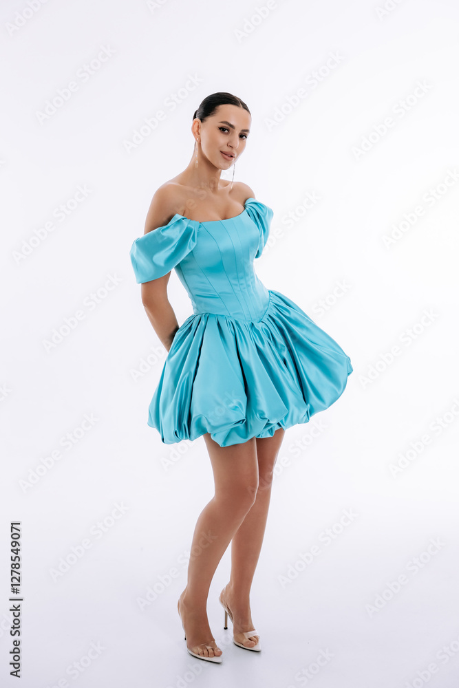 Sexy mulatto girl in a short evening luxury turquoise dress on a white background Sexy mulatto girl in a short evening luxury turquoise dress on a white background
