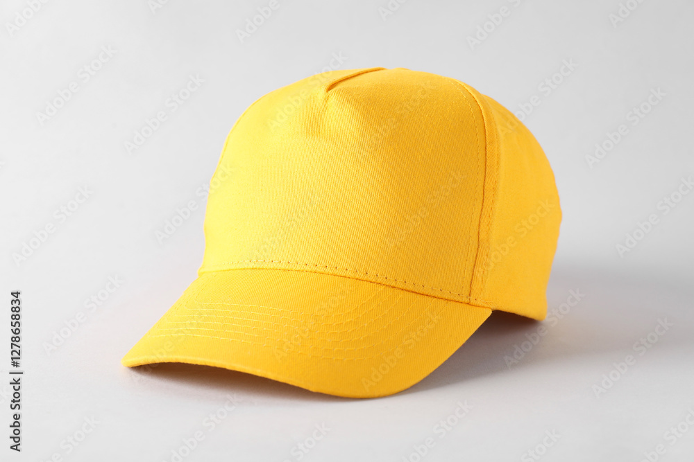 Fototapeta premium Stylish yellow baseball cap on light grey background. Mockup for design