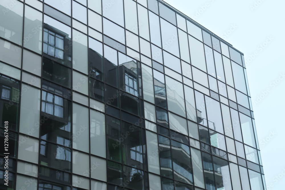Modern building with many windows against blue sky, low angle view Modern building with many windows against blue sky, low angle view