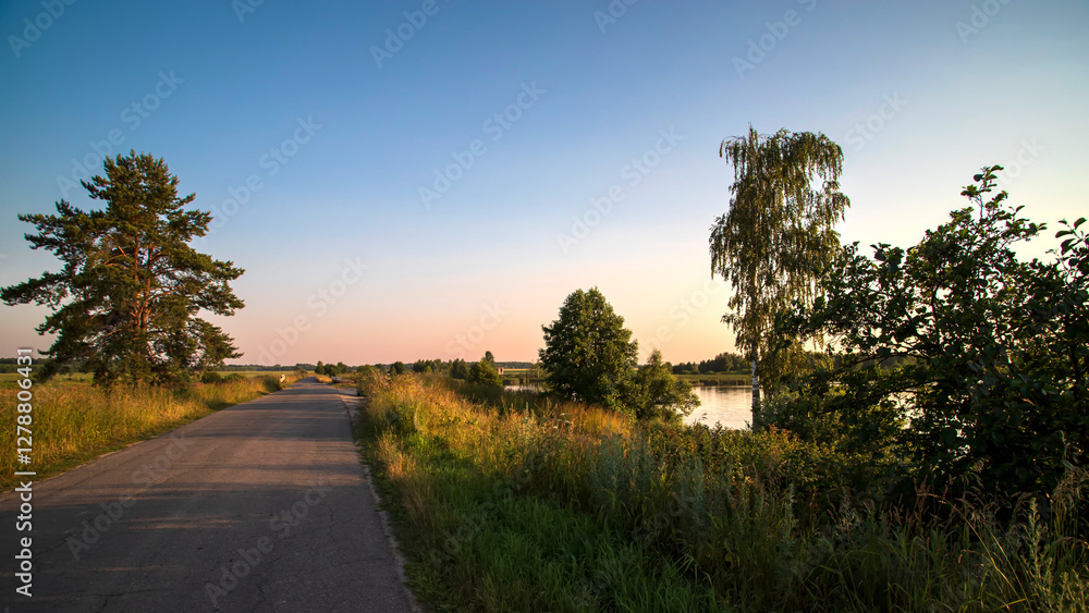 Summer landscape with asphalt road next to a field on the sunset. Summer landscape with asphalt road next to a field on the sunset.
