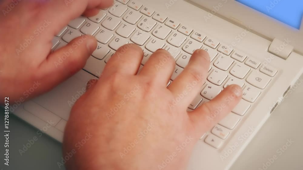 Hands of a man typing on a white laptop with a blue screen. Typing on a computer Hands of a man typing on a white laptop with a blue screen. Typing on a computer