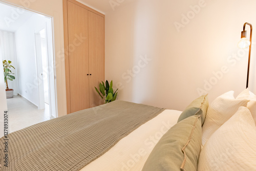 a small bedroom with fitted wooden wardrobe in Mediterranean holiday apartment 