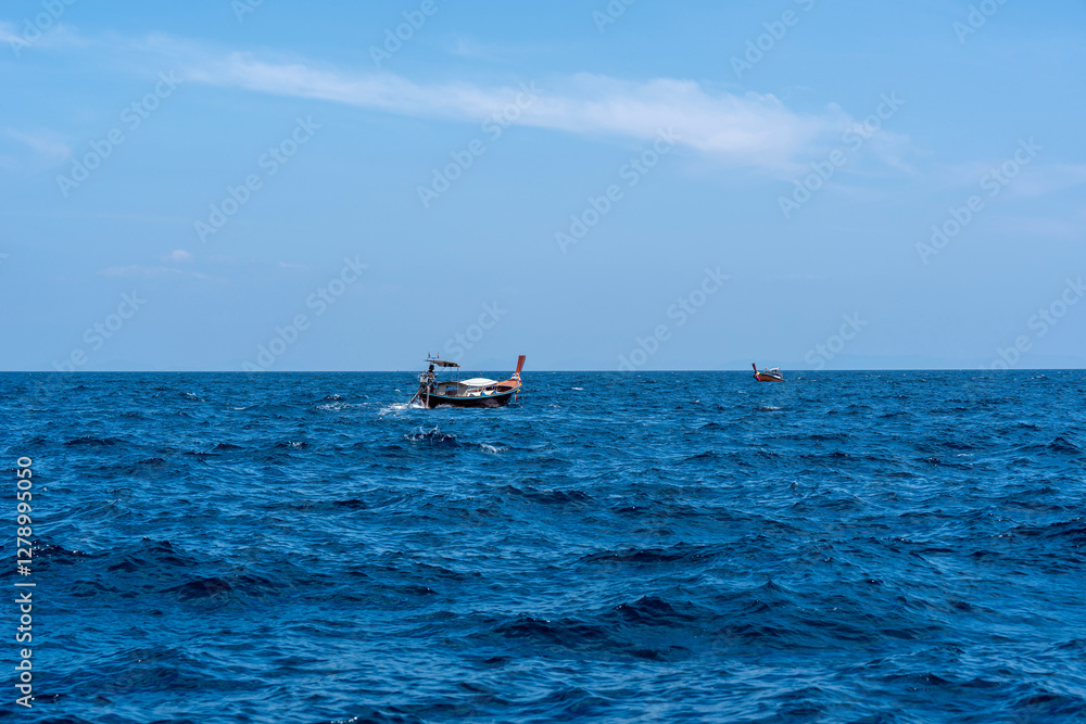 Two traditional Thai long-tailed boats are sailing towards each other in Andaman Sea, Thailand Two traditional Thai long-tailed boats are sailing towards each other in Andaman Sea, Thailand