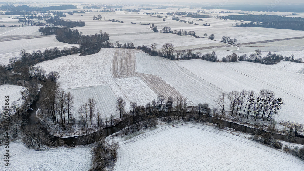 Obraz premium meanders of the prosny river in fields and meadows on a winter day. river bends, beautiful nature. snow on the fields.