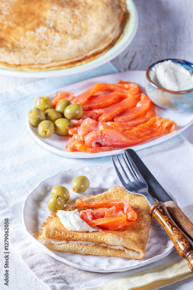 Pancakes with gravlax, cottage cheese and olives. A traditional dish for Maslenitsa or Carnival.