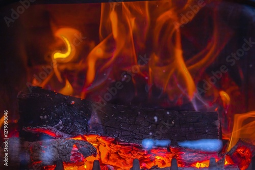 Red-hot coals and burning firewood in a stove – a warm atmosphere of home comfort