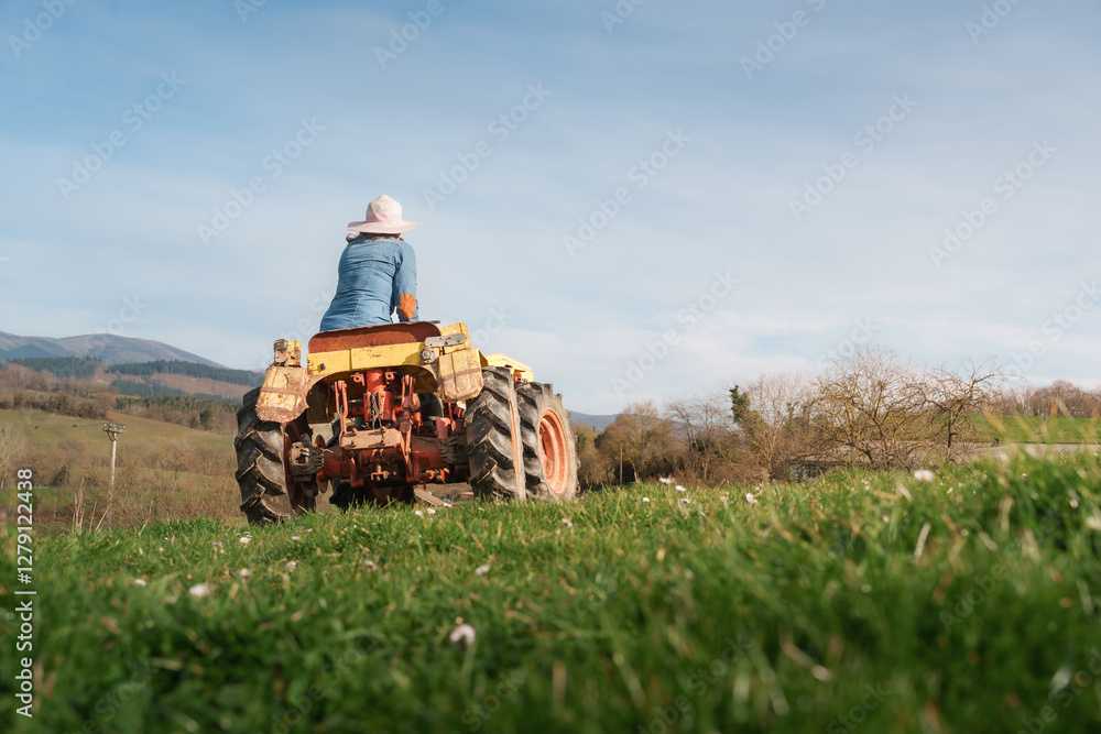 Obraz premium Female farmer driving a tractor in a green field, celebrating her contribution to agriculture on international workers' day