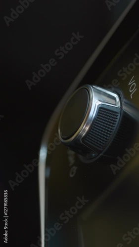 Vertical Format Video of Adjusting volume of speaker with fingers to listen to music. Press the car audio button. The driver turned to the radio