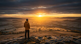 Solo Explorer Overlooking Dramatic Winter Sunset in North Yorkshire Moors, tranquil ambiance of snow clouds forming accompanied by subdued winter hues a undulating terrain 