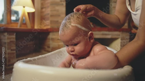 Baby being bathed toddler 6 months fun splashing water bath time drying off