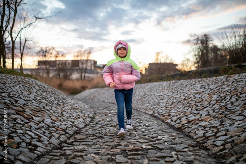 Portrait of little adorable girl walking in park