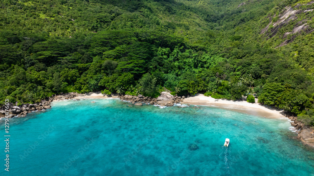 Granite rocks nestled in dense tropical forest next to a beach with clear turquoise water. Anse Major. Seychelles, Mahe. Granite rocks nestled in dense tropical forest next to a beach with clear turquoise water. Anse Major. Seychelles, Mahe.