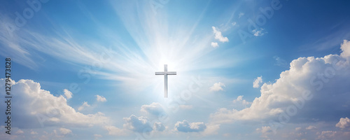 Bright sunlight shines through clouds, illuminating a cross in the clear blue sky during midday hours