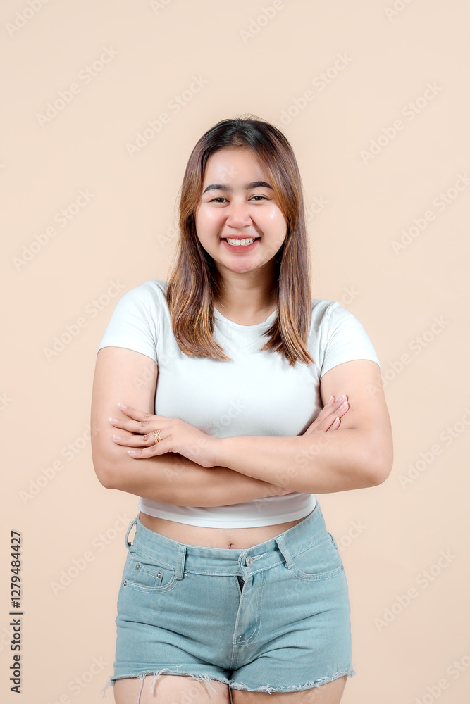 A confident young woman smiling with her arms crossed, showcasing a relaxed demeanor against a soft beige background, radiating positivity and self-assurance. A confident young woman smiling with her arms crossed, showcasing a relaxed demeanor against a soft beige background, radiating positivity and self-assurance.