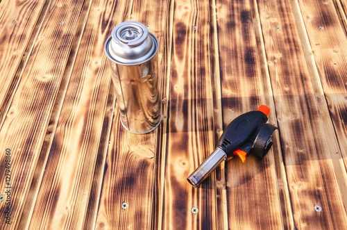 Gas cylinder and burner on the wooden background.