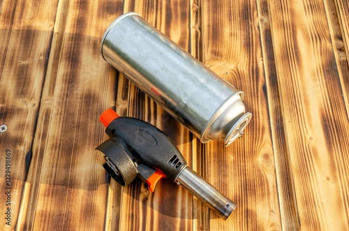 Gas cylinder and burner on the wooden background.