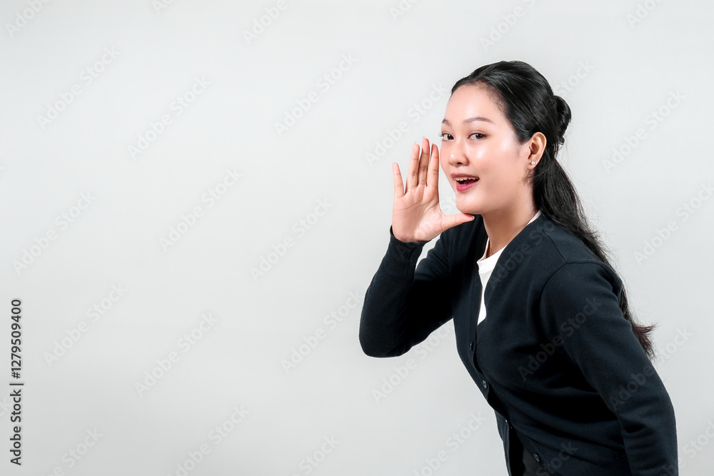 A young woman in a black cardigan leans forward, cupping her hand to her mouth as if shouting or calling out. This gesture conveys excitement and enthusiasm. A young woman in a black cardigan leans forward, cupping her hand to her mouth as if shouting or calling out. This gesture conveys excitement and enthusiasm.