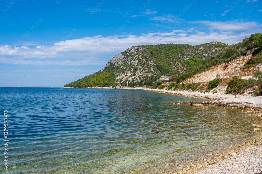 Naklejka premium Stunning Adriatic coastline with crystal-clear turquoise waters, rocky shoreline, lush Mediterranean greenery, and a peaceful secluded beach