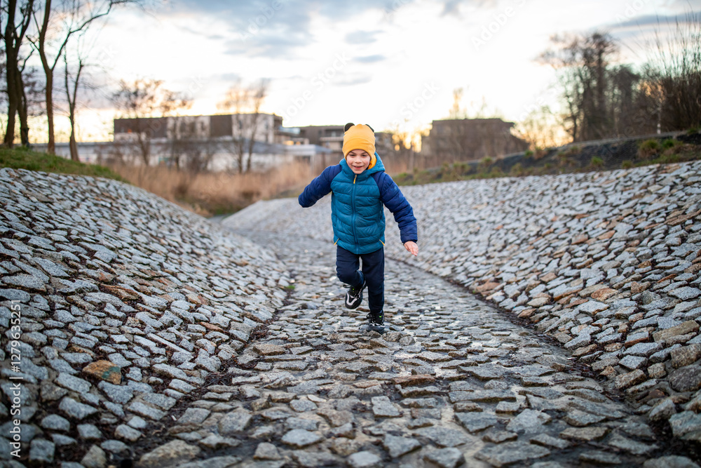 Portrait of little adorable boy walking in park