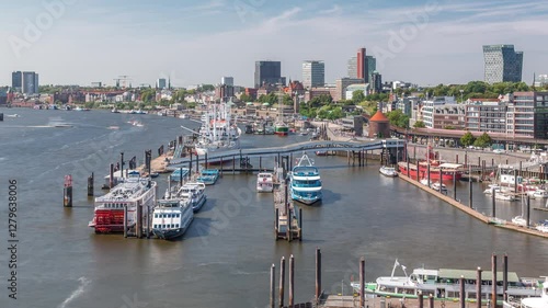 Aerial timelapse of Elbe riverside in Hamburg, Germany. Scenic view to waterfront with boats near the pier, Jan Fedder Promenade, marina and ships passing by. Vibrant cityscape by the Elbe River photo