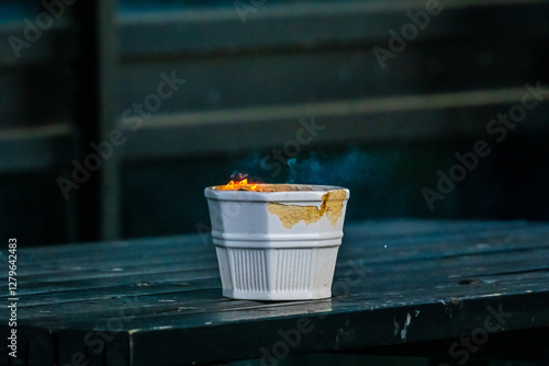 Foto Fire rising from an ashtray on a table..