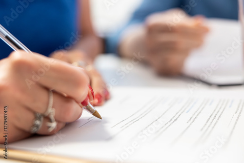 Elderly person signing the financial document terms in modern office, agreeing to retirement and investment plan. Old woman signs the contract to secure the future income. Close up. photo