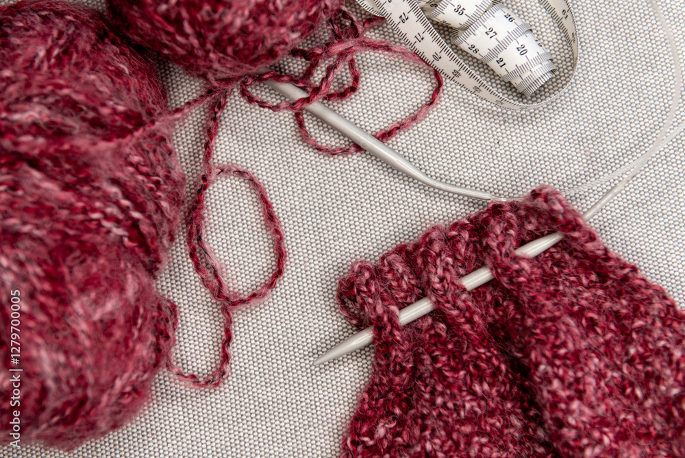 Fototapeta premium yarns, knitting needles and pattern sample on grey background.
