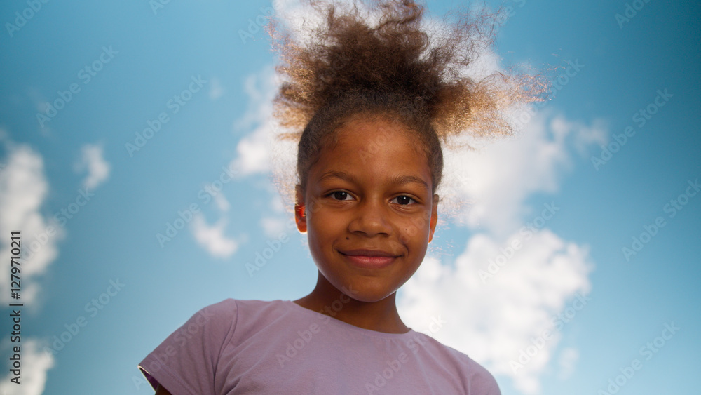 Bottom view little girl happy ethnic African American child curly schoolgirl preteen pupil school student studying looking at camera sky sunny outdoors female daughter smiling cute kid baby childcare Bottom view little girl happy ethnic African American child curly schoolgirl preteen pupil school student studying looking at camera sky sunny outdoors female daughter smiling cute kid baby childcare