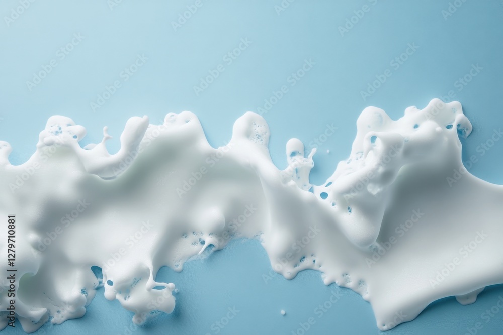 Fototapeta premium White foam spills against a clean light blue background