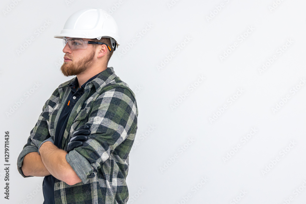 Portrait of a male builder. Engineer in overalls and helmet on a light background. Portrait of a male builder. Engineer in overalls and helmet on a light background.