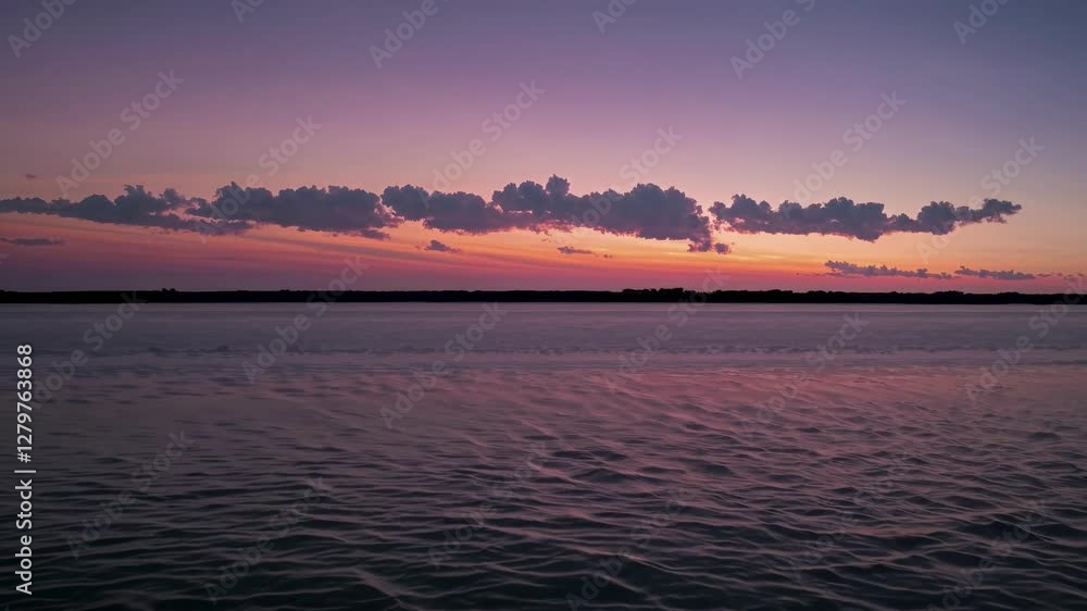 A serene sunset video captures a wide-angle view of rippling water and a colorful sky, blending tranquility with natural beauty in a panoramic style. A serene sunset video captures a wide-angle view of rippling water and a colorful sky, blending tranquility with natural beauty in a panoramic style.