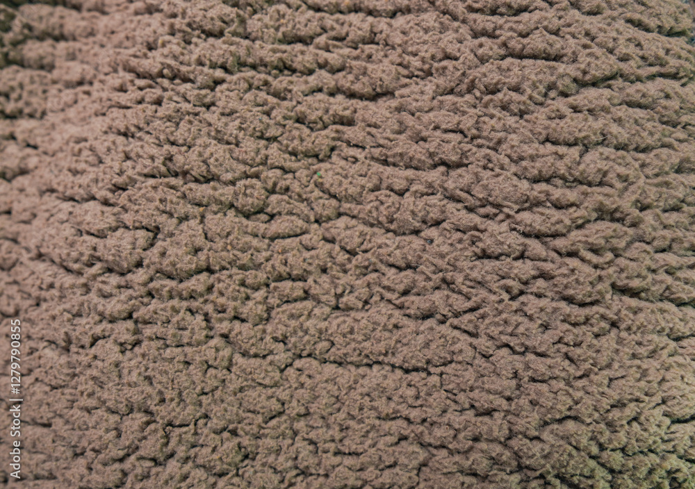 Close-up of a textured, dusty taupe fleece fabric. Close-up of a textured, dusty taupe fleece fabric.