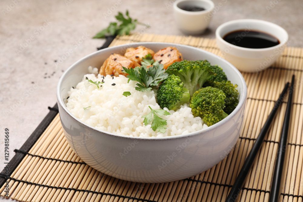 Tasty rice with broccoli and chicken served on grey table, closeup Tasty rice with broccoli and chicken served on grey table, closeup