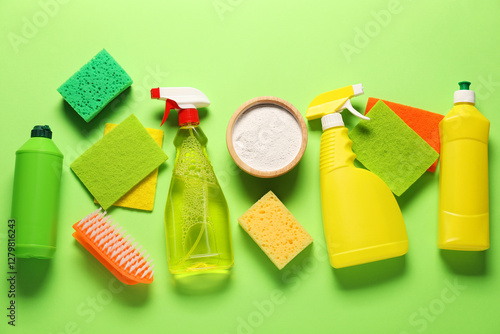 Fotografie Cleaning products and tools on green background, flat lay
