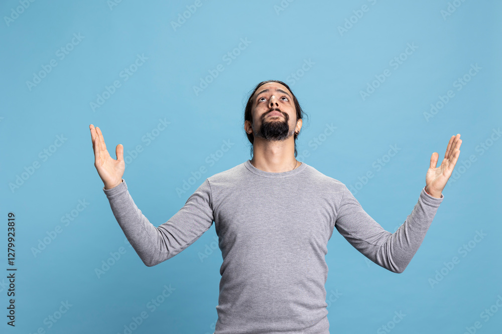 Naklejka premium Spiritual adult showing belief and faith in Jesus Christ asking for forgiveness, hopeful guy worshipping the Lord. Young person being emotional and wishful, pleading in meditation and Christianity.