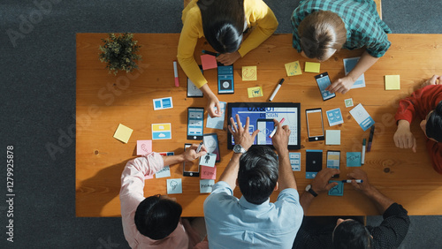 Top down view of business team writing idea on sticky note while planing for Ux Ui design for mobile phone interface. Group of creative designer working on wireframe prototype design. Convocation.