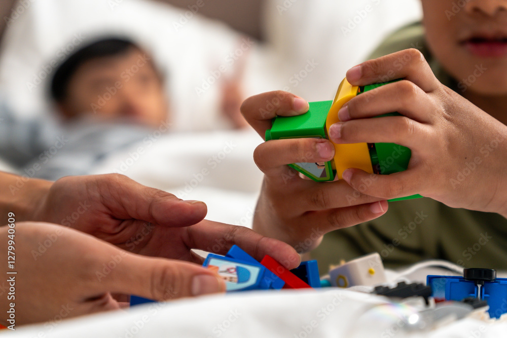 Fototapeta premium Siblings playing with their favorite toys on the bed before bedtime