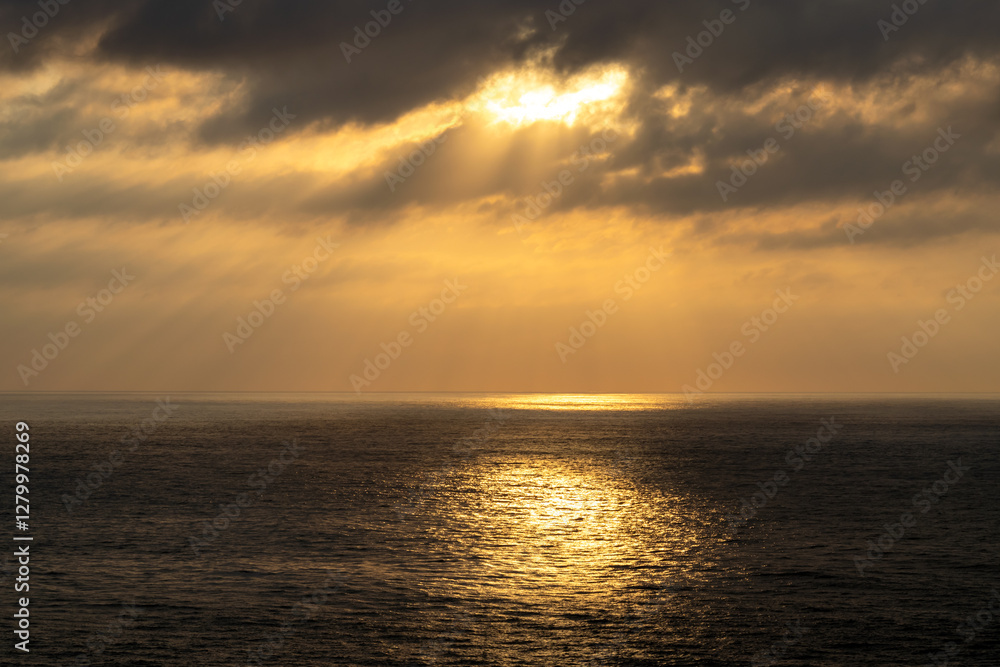 Dark cloudscape over the vast ocean with calm and sparkling reflections on the water. Dark cloudscape over the vast ocean with calm and sparkling reflections on the water.