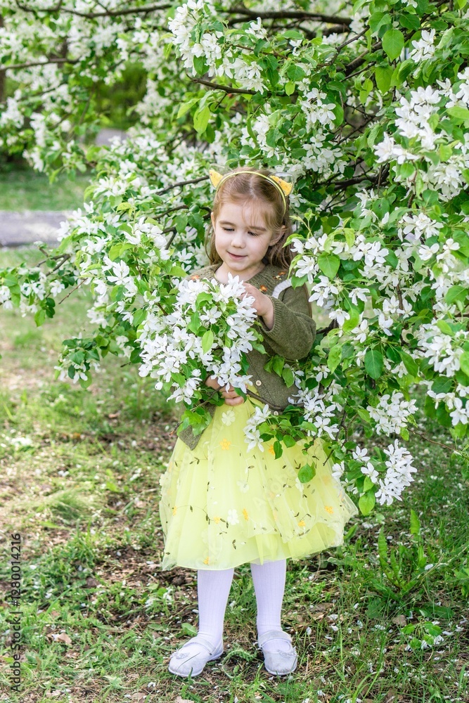 Cute little girl in bright yellow dress exploring beautiful apple orchard in full spring bloom. Cute little girl in bright yellow dress exploring beautiful apple orchard in full spring bloom.