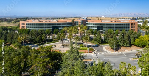 Aerial view of Googleplex office buildings, lush landscaping, and city streets. Sunny day, business district. Mountain View, California, USA